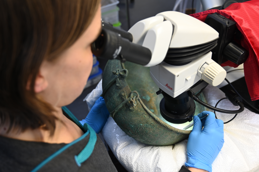 Reinigung eines Bronzekessels aus einem Brandgrab in Castaneda (ältere Eisenzeit, 7./6. Jh. v. Chr.)