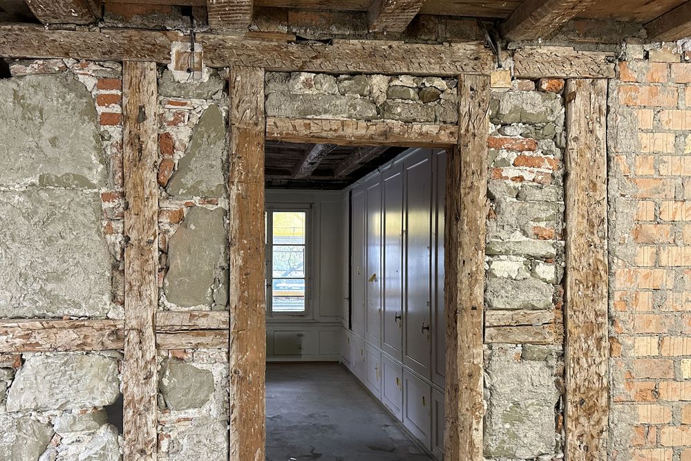 Freigelegte Wand im Erdgeschoss, in Hintergrund Reste eines Täfers aus dem 19. Jahrhundert und Einbauschränke von 1952.