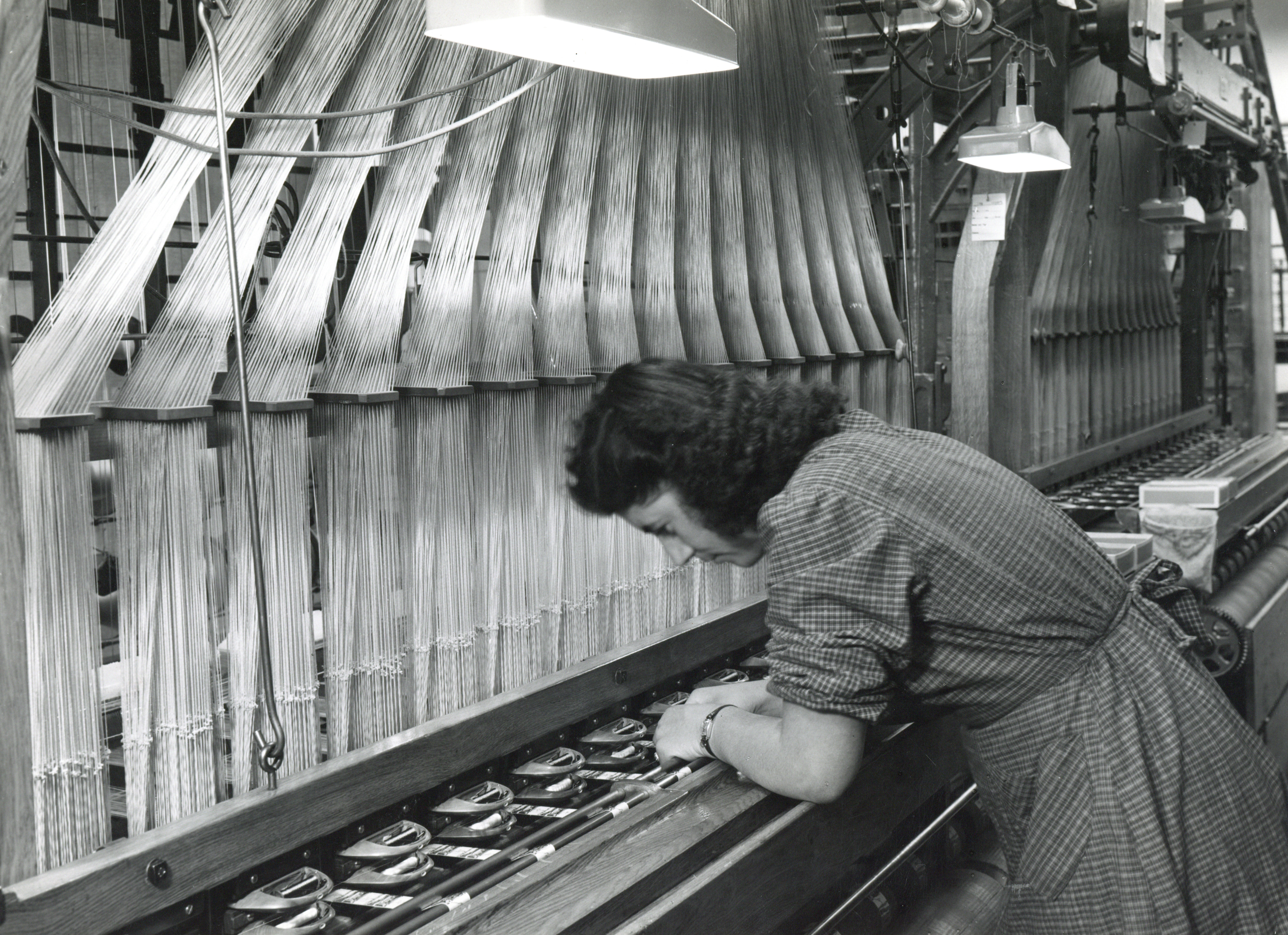 Arbeiterin an einem Jacquard-Webstuhl bei Bally Band in Schönenwerd, um 1950.